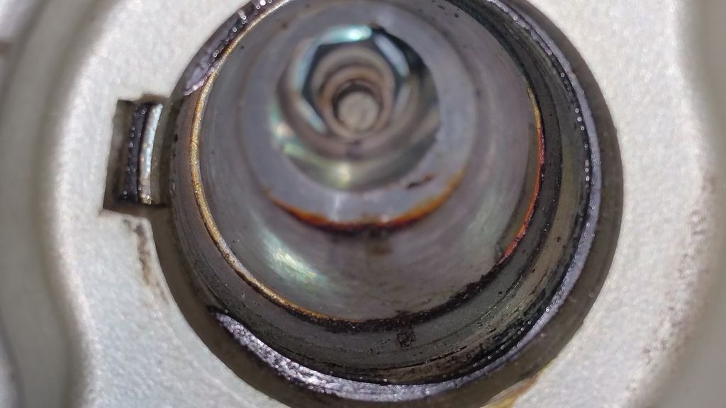 How should I clean the residue inside the coil pack/spark plug wells?